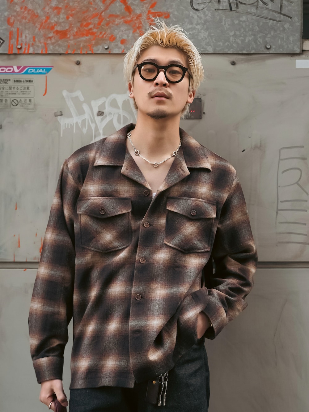 ブラウン系のシャツ/ブラウス、ブラック系のデニムパンツ、レッド系のボストンバッグを着用したメンズの春コーディネートの2枚目の写真