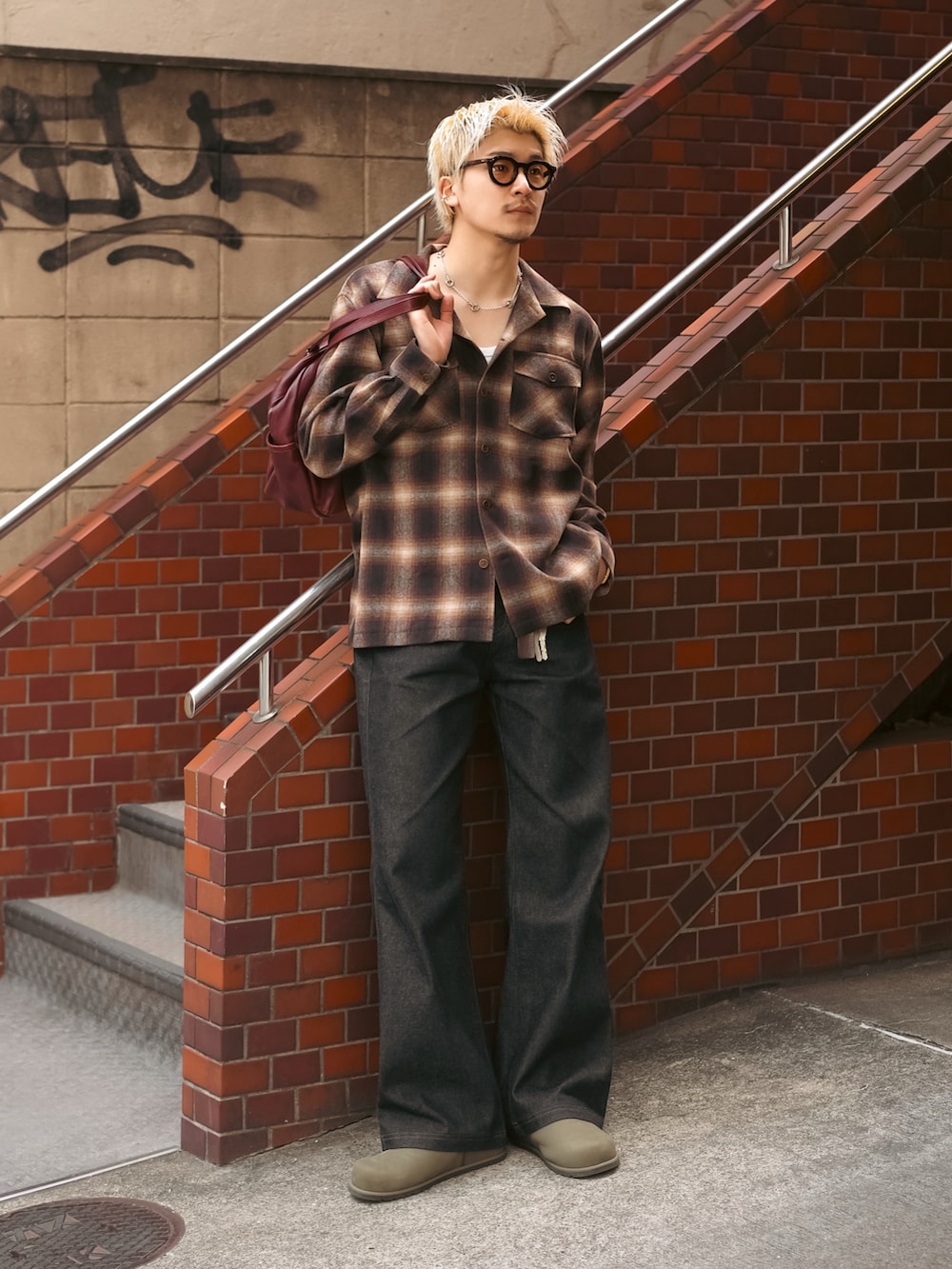 ブラウン系のシャツ/ブラウス、ブラック系のデニムパンツ、レッド系のボストンバッグを着用したメンズの春コーディネートの4枚目の写真