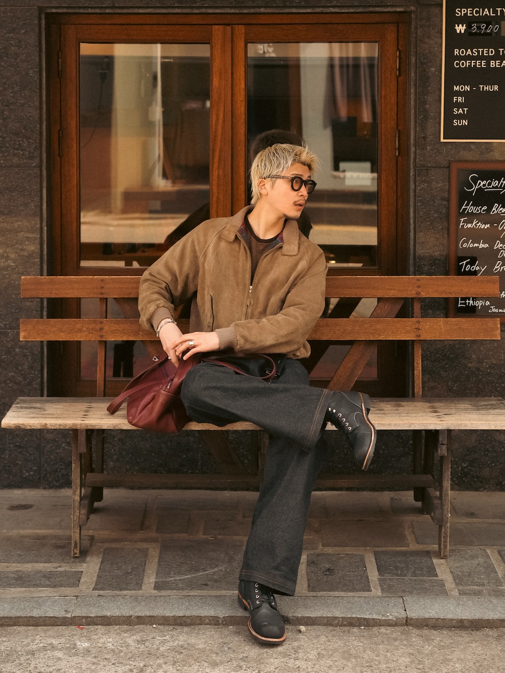 ブラック系のデニムパンツ、ブラック系のブーツ、ブラウン系のブルゾンを着用したメンズの春コーディネートの5枚目の写真