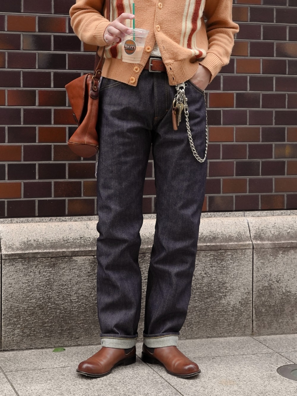 その他のデニムパンツ、ブラウン系のブーツ、ブラウン系のショルダーバッグを着用したメンズの春コーディネートの4枚目の写真