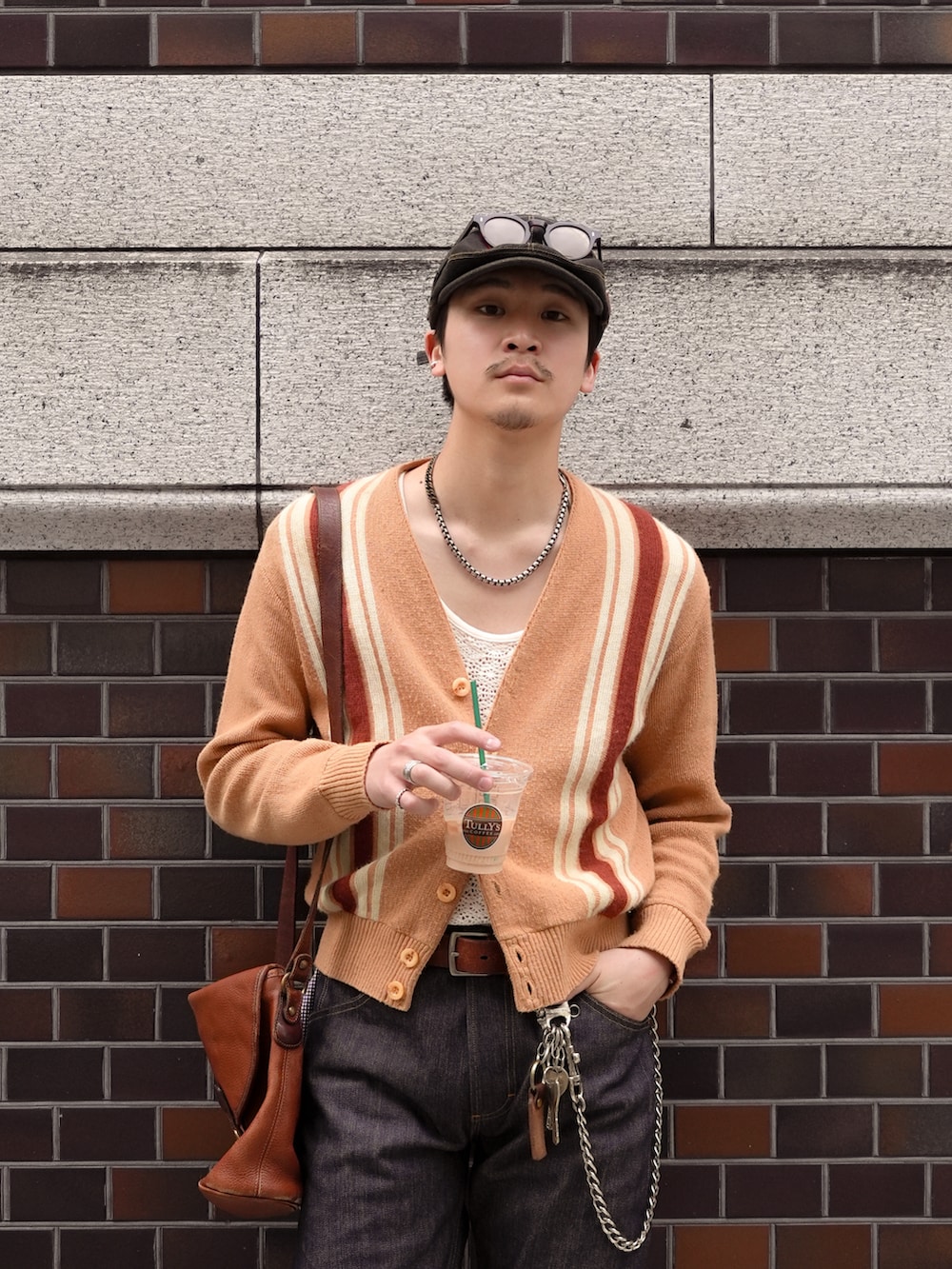その他のデニムパンツ、ブラウン系のブーツ、ブラウン系のショルダーバッグを着用したメンズの春コーディネートの3枚目の写真