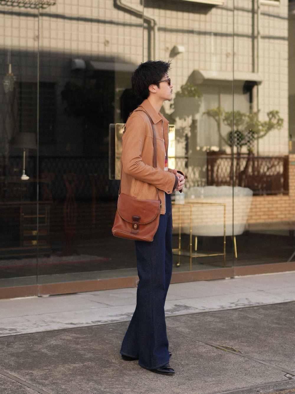 ブルー系のデニムパンツ、ベージュ系のその他アウター、レッド系のニット/セーターを着用したメンズの春コーディネートの3枚目の写真