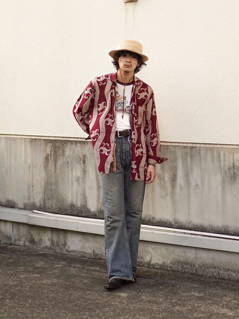 ブルー系のデニムパンツ、ブラック系のブーツ、レッド系のシャツ/ブラウスを着用したメンズの夏コーディネートの2枚目の写真