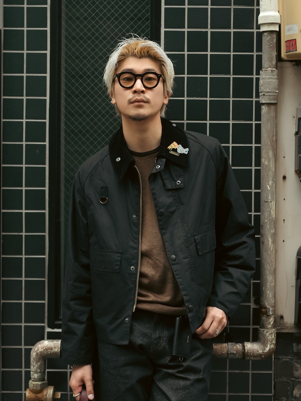 ブラック系のデニムパンツ、ブラウン系のローファー、ブラック系のブルゾンを着用したメンズの春コーディネートの5枚目の写真