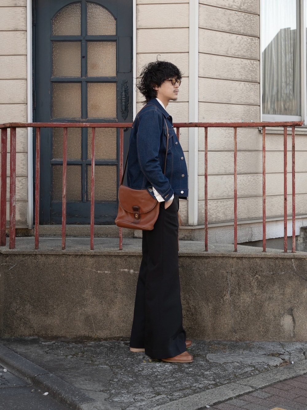 ブラック系のスラックス、ブラウン系のショルダーバッグ、ブラウン系のドレスシューズを着用したメンズの冬コーディネートの3枚目の写真