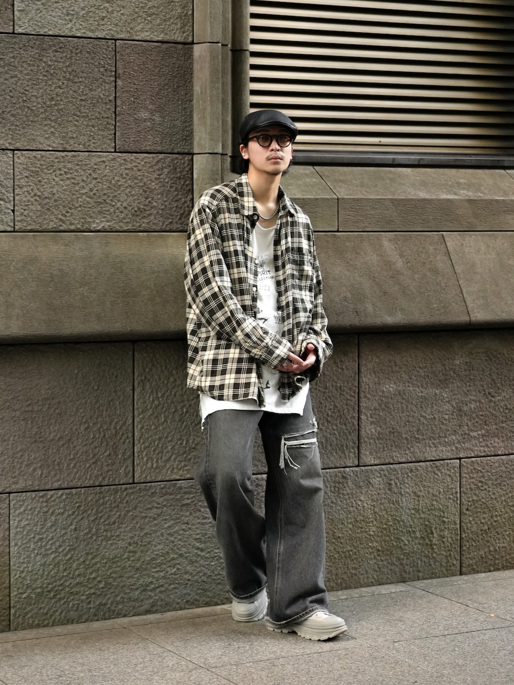 ブラック系のデニムパンツ、グレー系のスニーカー、ホワイト系のタンクトップを着用したメンズの秋コーディネートの3枚目の写真