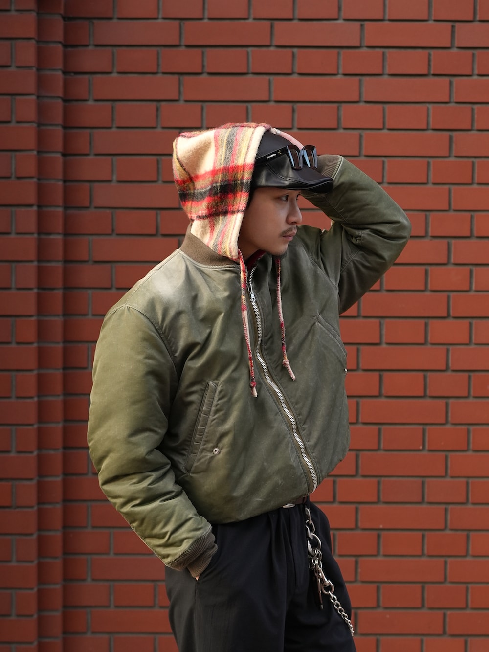 ブラック系のスラックス、ブラック系のスニーカー、グリーン系のMA-1を着用したメンズの冬コーディネートの2枚目の写真