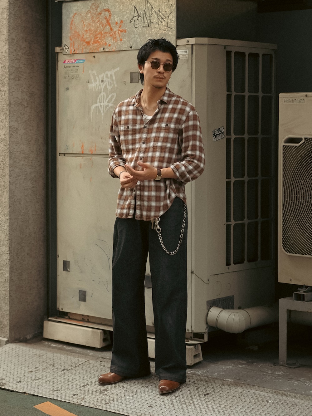 ホワイト系のタンクトップ、ブラック系のデニムパンツ、ブラウン系のブーツを着用したメンズの秋コーディネートの5枚目の写真