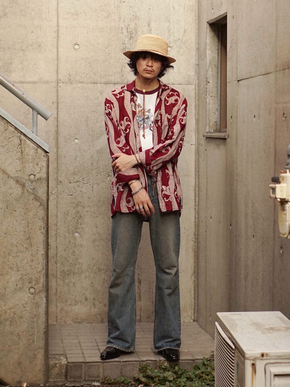 ブルー系のデニムパンツ、ブラック系のブーツ、レッド系のシャツ/ブラウスを着用したメンズの夏コーディネートの5枚目の写真