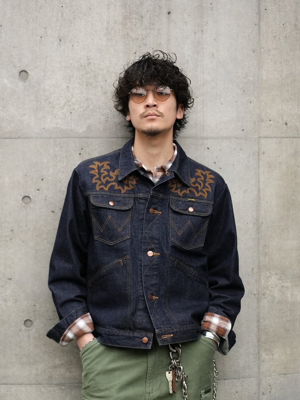 グリーン系のカーゴパンツ、ブラック系のブーツ、ブルー系のデニムジャケットを着用したメンズの春コーディネートの2枚目の写真