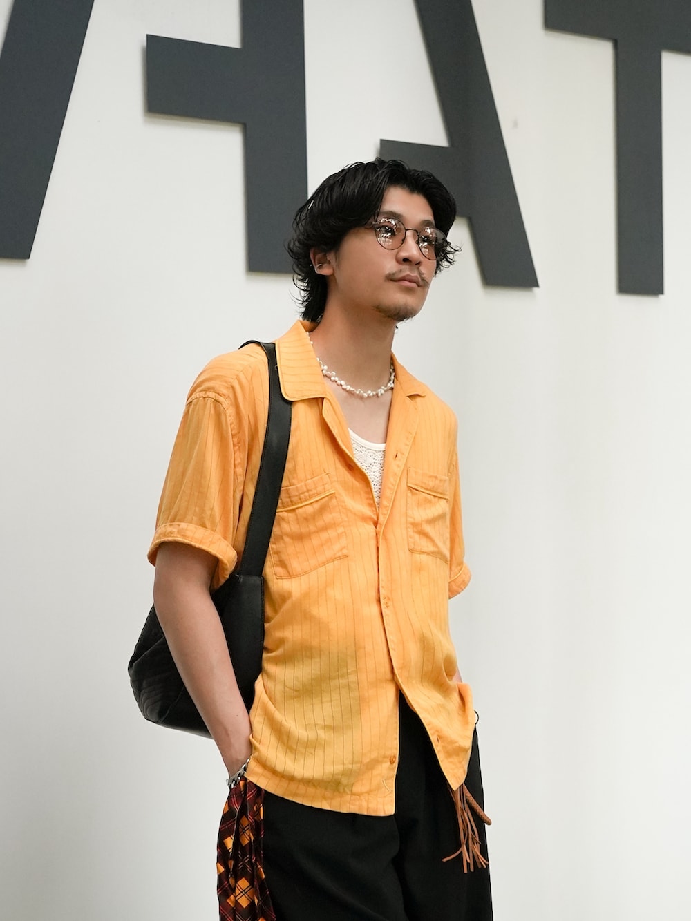 ブラック系のショルダーバッグ、ベージュ系のシャツ/ブラウス、ブラック系のスラックスを着用したメンズの夏コーディネートの2枚目の写真
