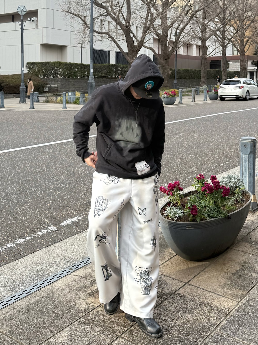 ブラック系のスウェット、ホワイト系のその他パンツ、ブラック系のブーツを着用したメンズの春コーディネートの2枚目の写真