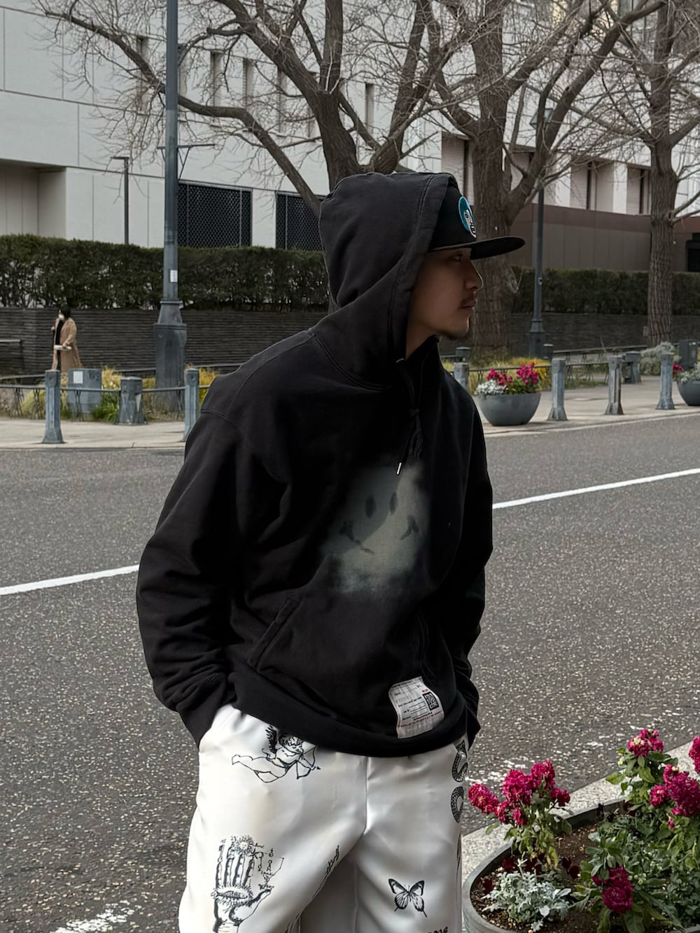 ブラック系のスウェット、ホワイト系のその他パンツ、ブラック系のブーツを着用したメンズの春コーディネートの3枚目の写真