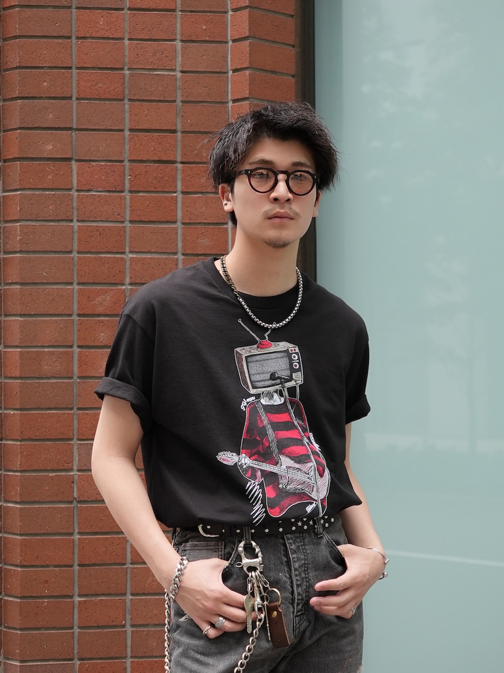 ブラック系のデニムパンツ、ブラック系のTシャツ/カットソー、ブラック系のブーツを着用したメンズの春コーディネートの2枚目の写真
