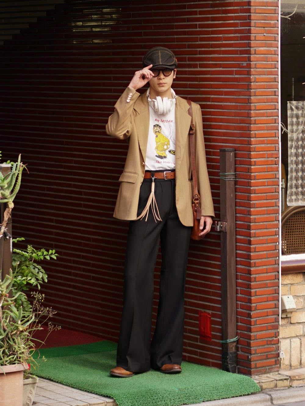 ブラック系のスラックス、ブラウン系のドレスシューズ、ホワイト系のTシャツ/カットソーを着用したメンズの春コーディネートの5枚目の写真