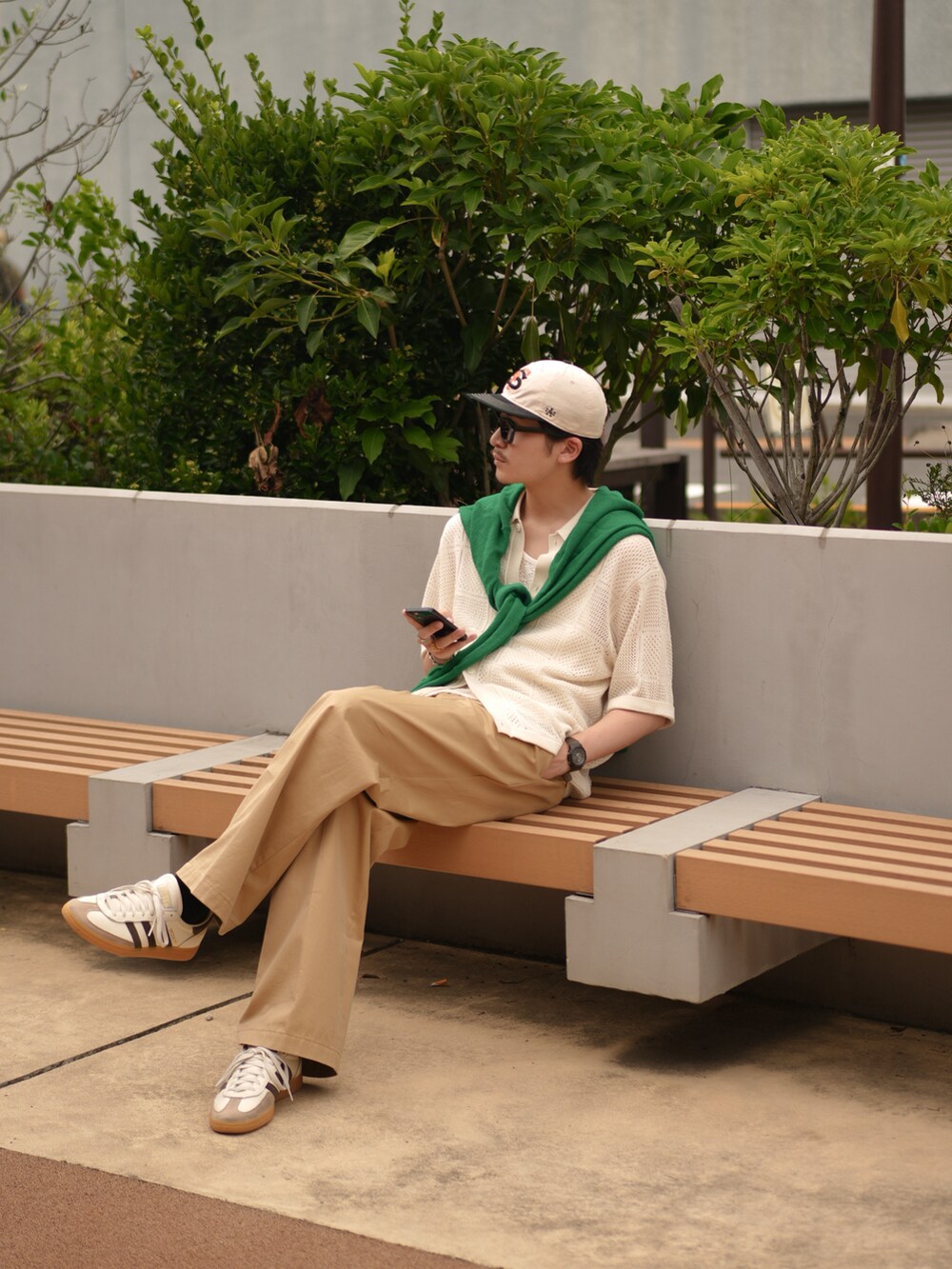 ベージュ系のチノパンツ、ホワイト系のスニーカー、グリーン系のカーディガン/ボレロを着用したメンズの夏コーディネートの4枚目の写真