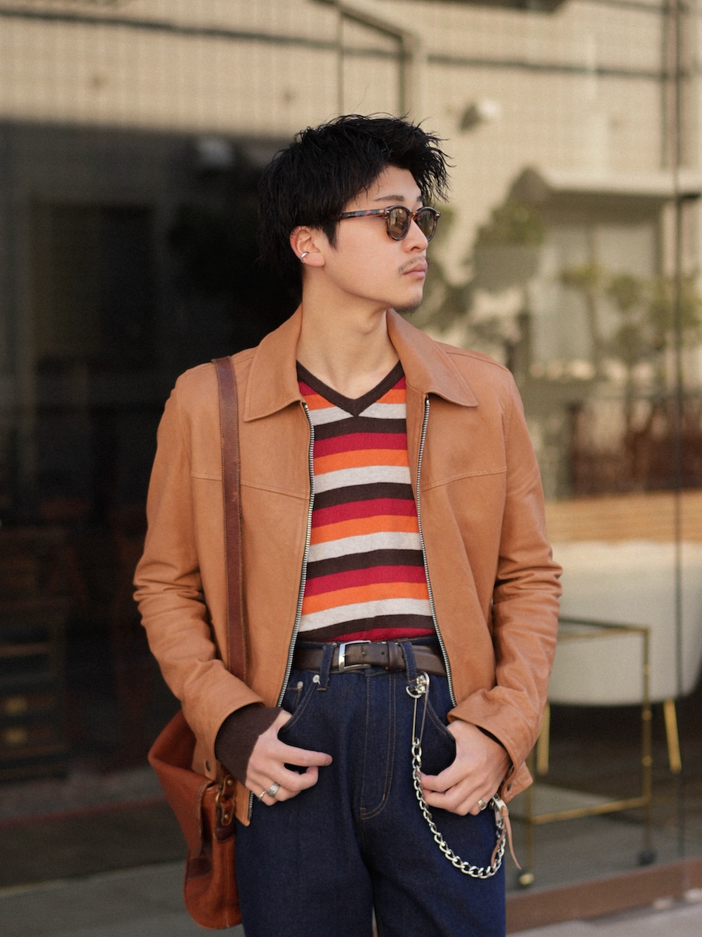 ブルー系のデニムパンツ、ベージュ系のその他アウター、レッド系のニット/セーターを着用したメンズの春コーディネートの2枚目の写真