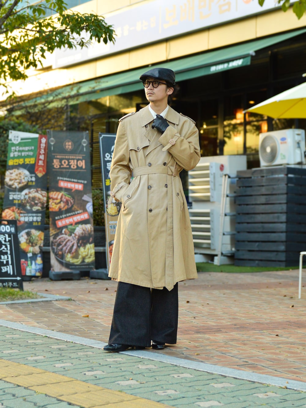 ベージュ系のトレンチコート、ブラック系のデニムパンツ、ブラック系のブーツを着用したメンズの秋コーディネートの4枚目の写真