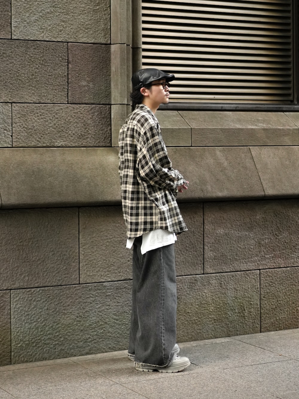 ブラック系のデニムパンツ、グレー系のスニーカー、ホワイト系のタンクトップを着用したメンズの秋コーディネートの5枚目の写真