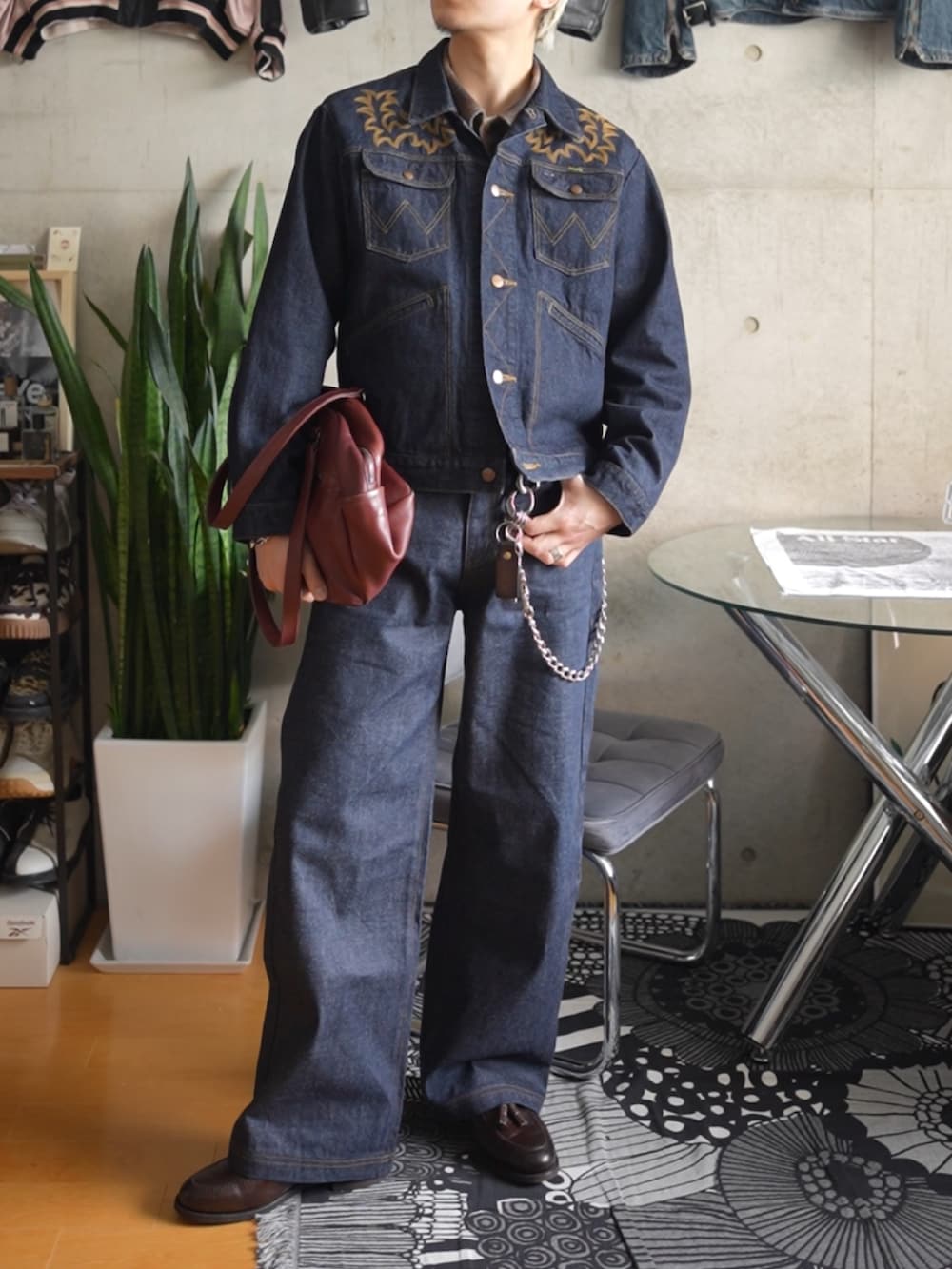 ブラック系のデニムパンツ、ブラウン系のローファー、ブルー系のデニムジャケットを着用したメンズの冬コーディネートの3枚目の写真