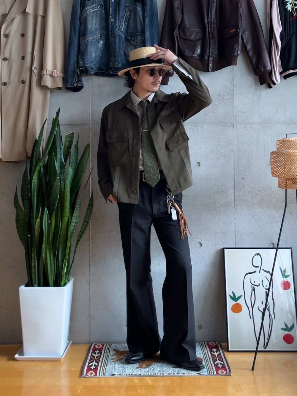 ブラック系のスラックス、グリーン系のミリタリージャケット、ブラック系のスリッポンを着用したメンズの秋コーディネートの3枚目の写真