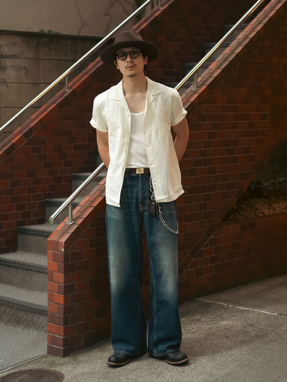 ベージュ系のシャツ/ブラウス、ブルー系のデニムパンツ、ブラック系のブーツを着用したメンズの夏コーディネートの5枚目の写真