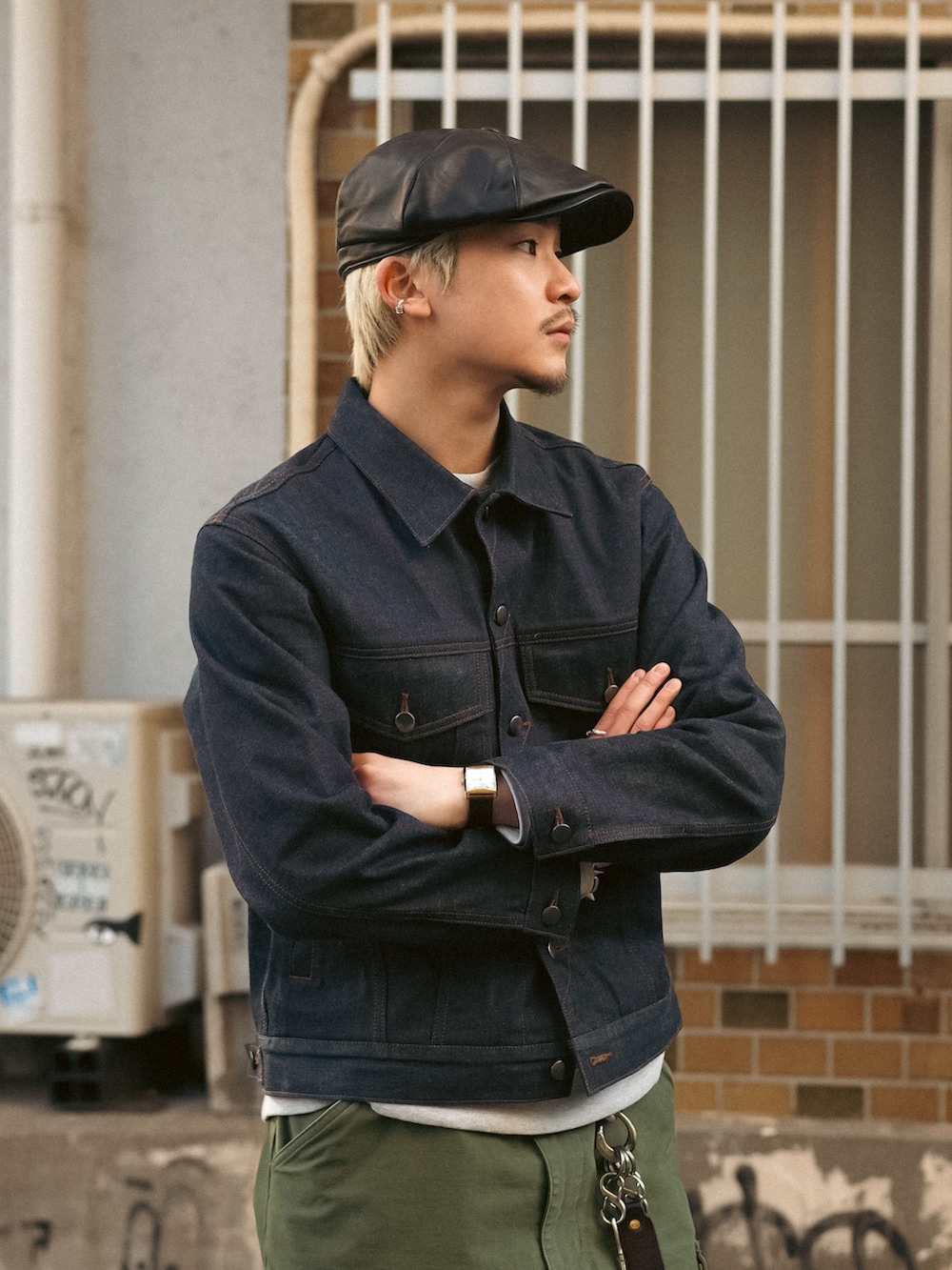 ブラック系のデニムジャケット、グリーン系のカーゴパンツ、ブラック系のブーツを着用したメンズの冬コーディネートの2枚目の写真