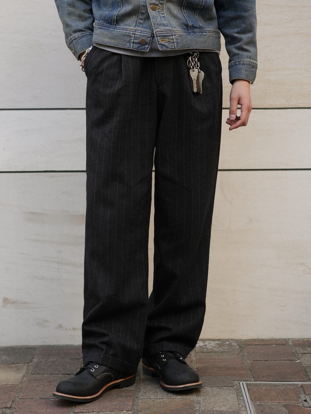 ブラック系のスラックス、ブラック系のブーツ、ブルー系のデニムジャケットを着用したメンズの冬コーディネートの4枚目の写真