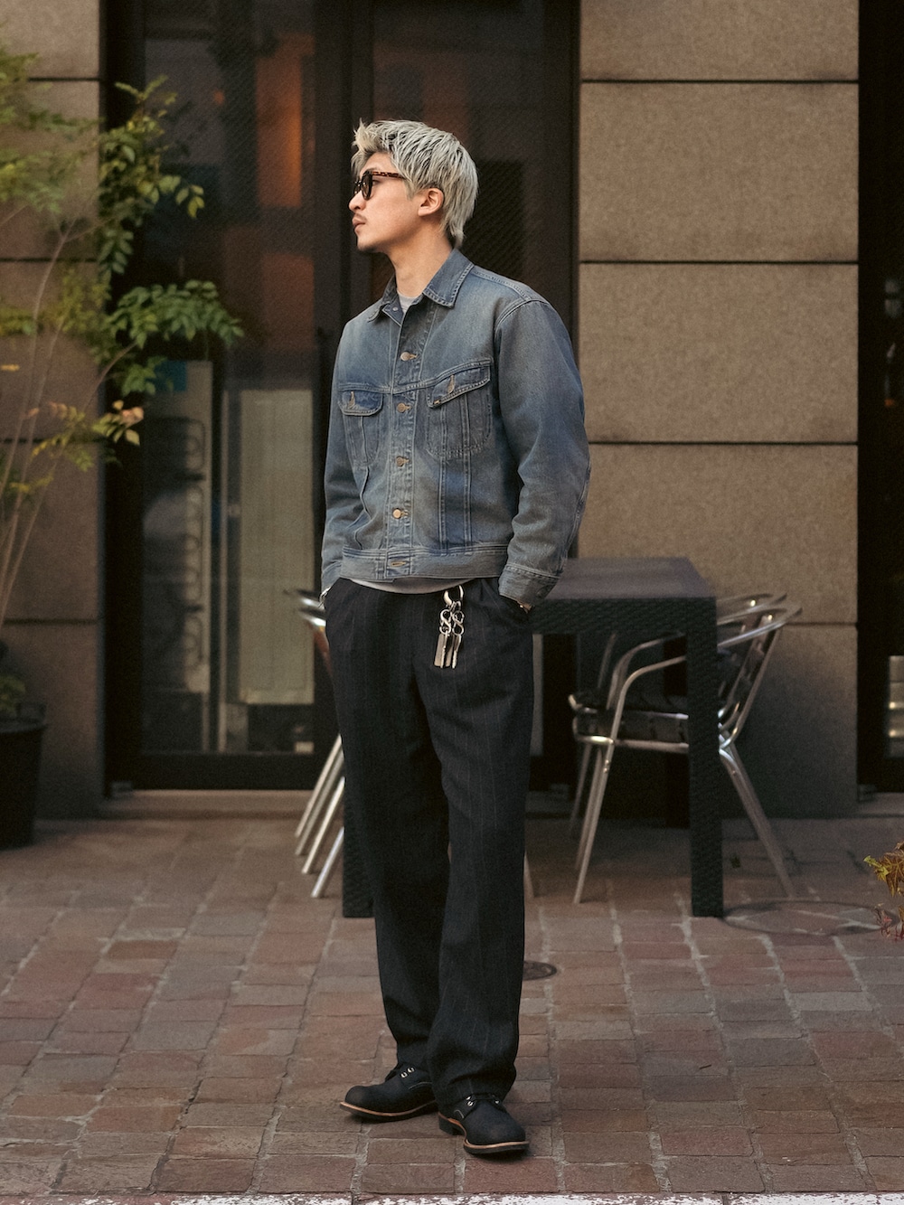 ブラック系のスラックス、ブラック系のブーツ、ブルー系のデニムジャケットを着用したメンズの冬コーディネートの3枚目の写真