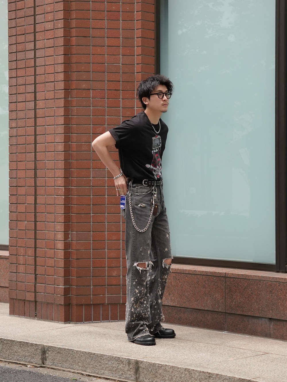 ブラック系のデニムパンツ、ブラック系のTシャツ/カットソー、ブラック系のブーツを着用したメンズの春コーディネートの3枚目の写真
