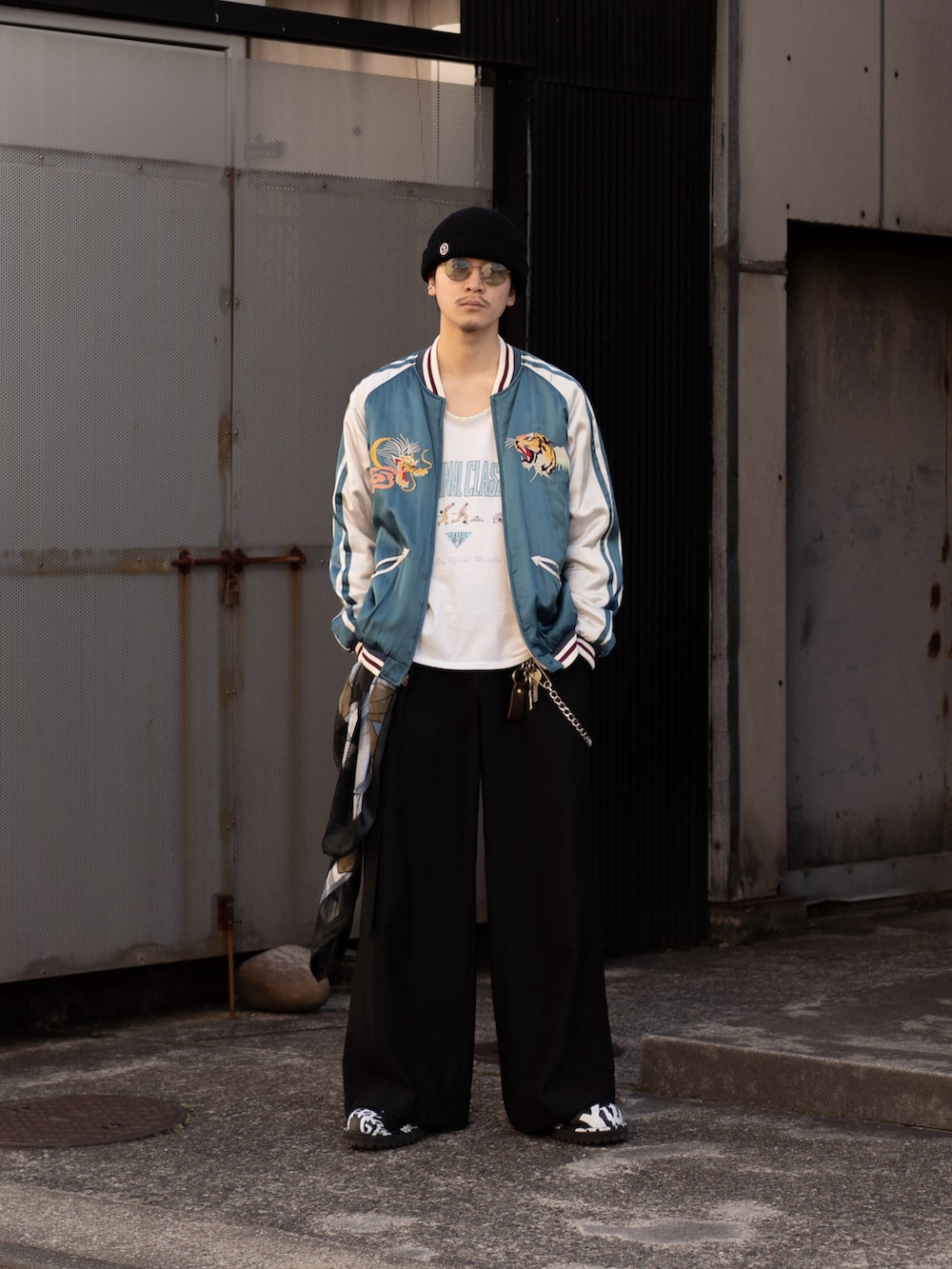 ブラック系のその他パンツ、ブラック系のブーツ、ブルー系のスカジャンを着用したメンズの春コーディネートの5枚目の写真