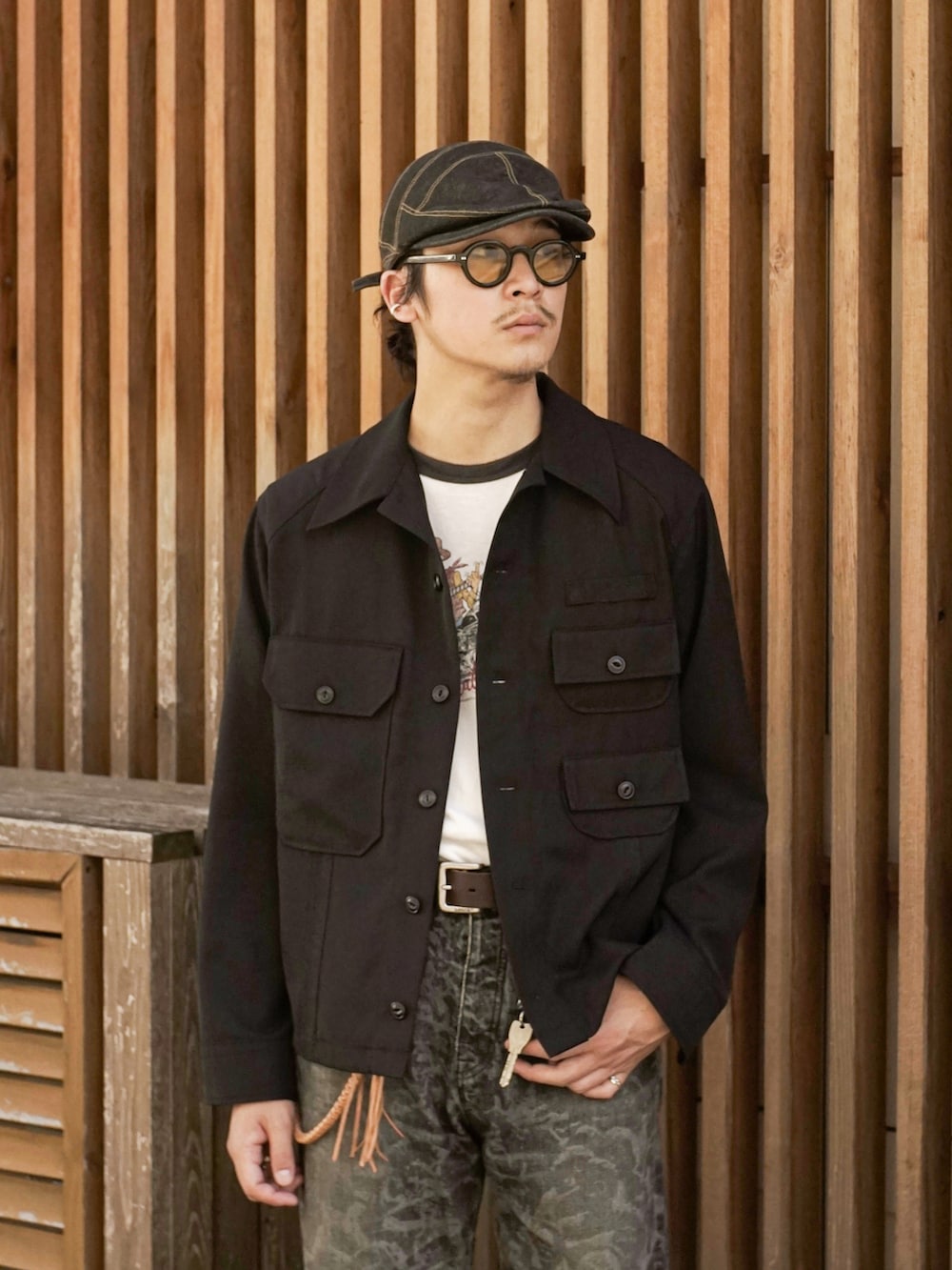 ブラック系のデニムパンツ、ブラック系のTシャツ/カットソー、ブラック系のブーツを着用したメンズの秋コーディネートの3枚目の写真