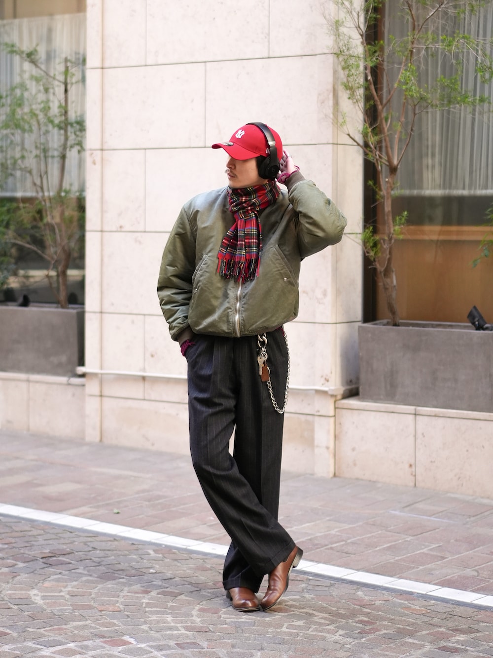 ブラック系のスラックス、ブラウン系のブーツ、グリーン系のMA-1を着用したメンズの冬コーディネートの3枚目の写真