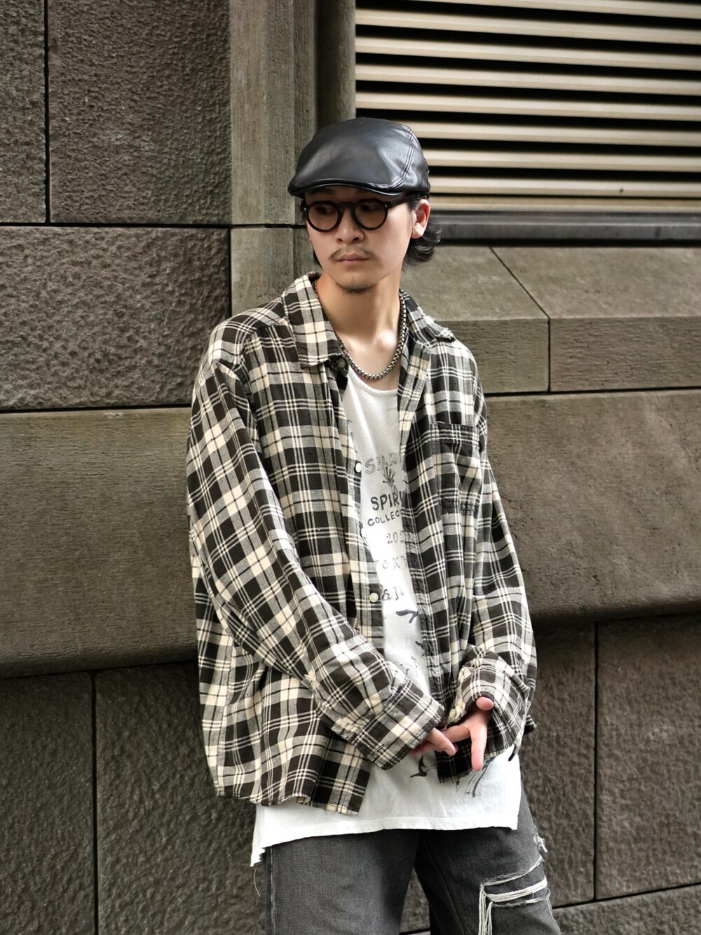 ブラック系のデニムパンツ、グレー系のスニーカー、ホワイト系のタンクトップを着用したメンズの秋コーディネートの2枚目の写真