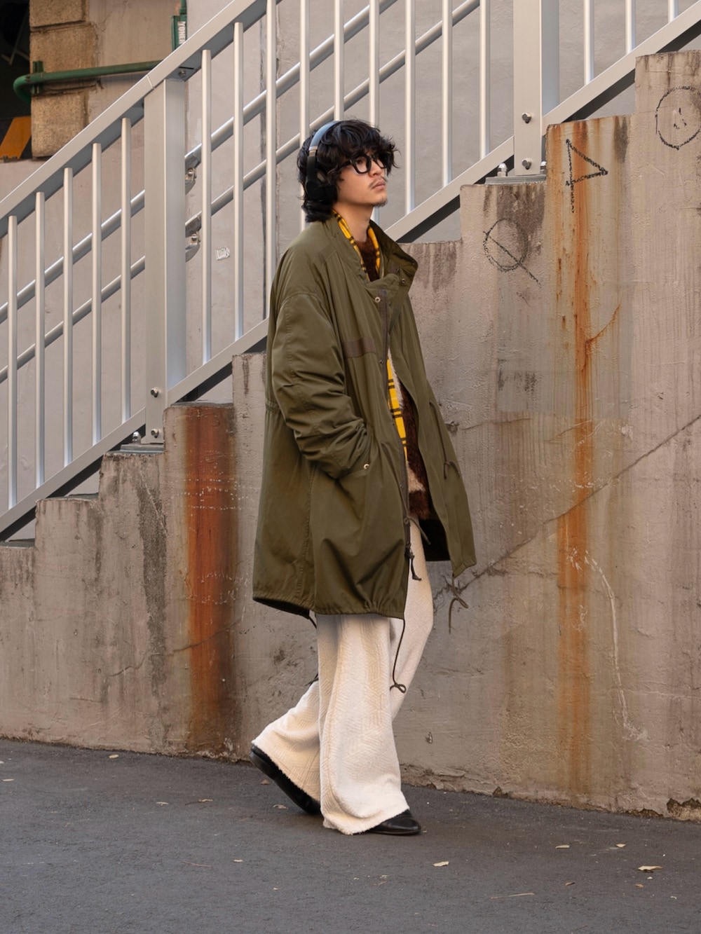 グリーン系のミリタリージャケット、ブラウン系のニット/セーター、ホワイト系のその他パンツを着用したメンズの冬コーディネートの2枚目の写真