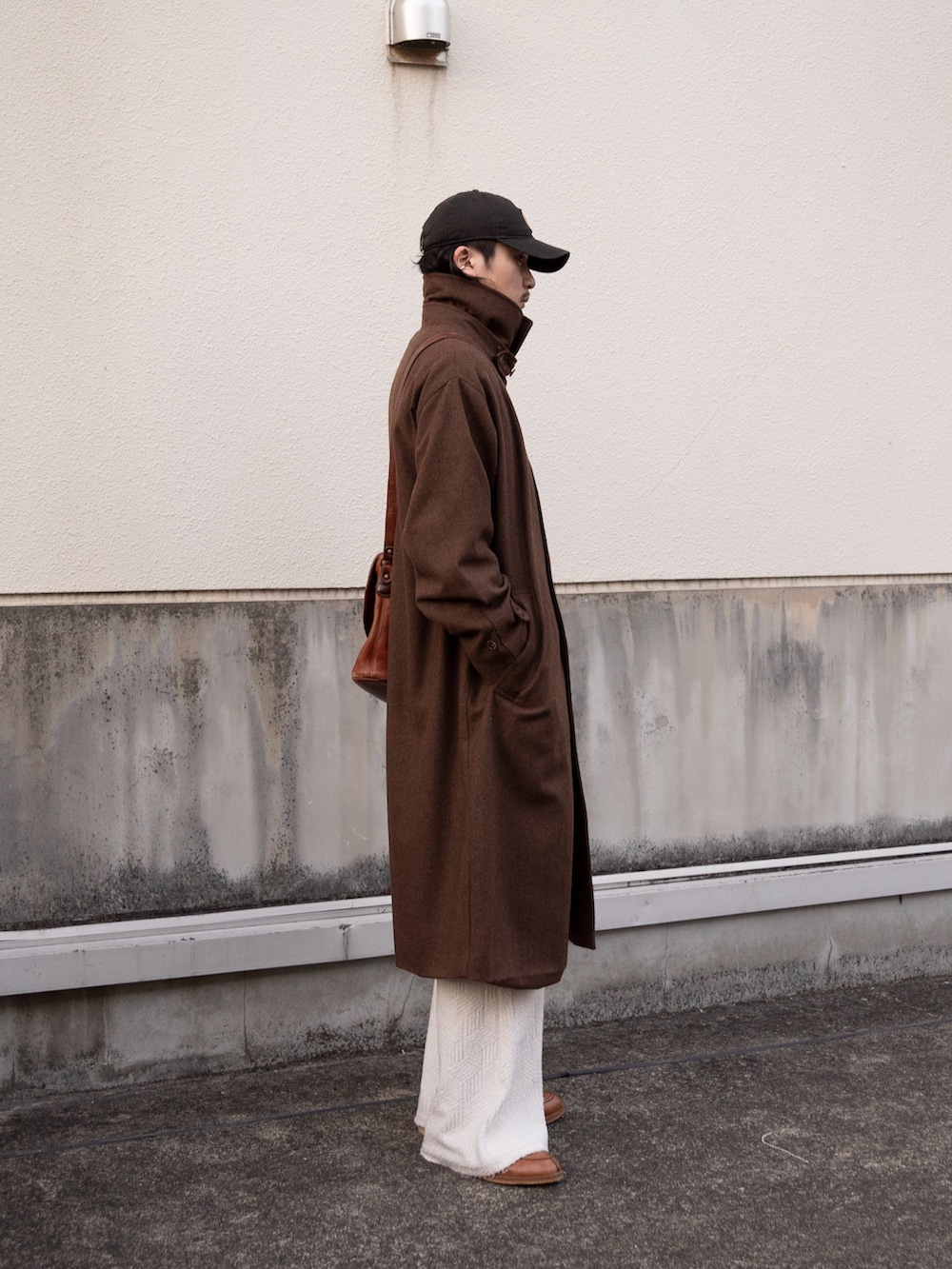 ブラウン系のステンカラーコート、ブラウン系のショルダーバッグ、ブラウン系のドレスシューズを着用したメンズの冬コーディネートの4枚目の写真