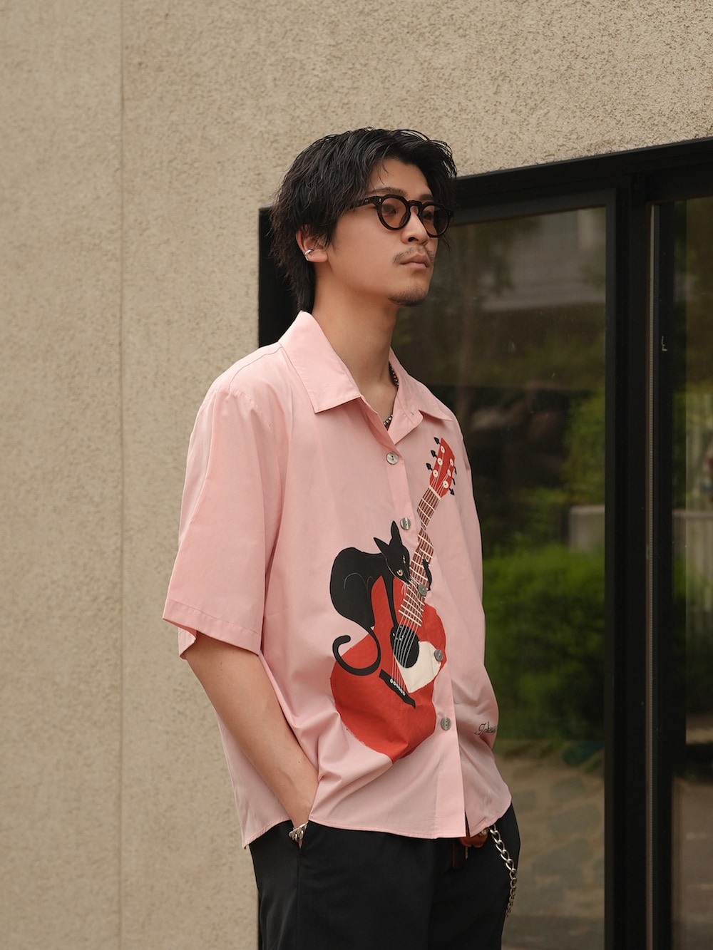 ブラック系のスラックス、ブラック系のスリッポン、ピンク系のシャツ/ブラウスを着用したメンズの夏コーディネートの4枚目の写真