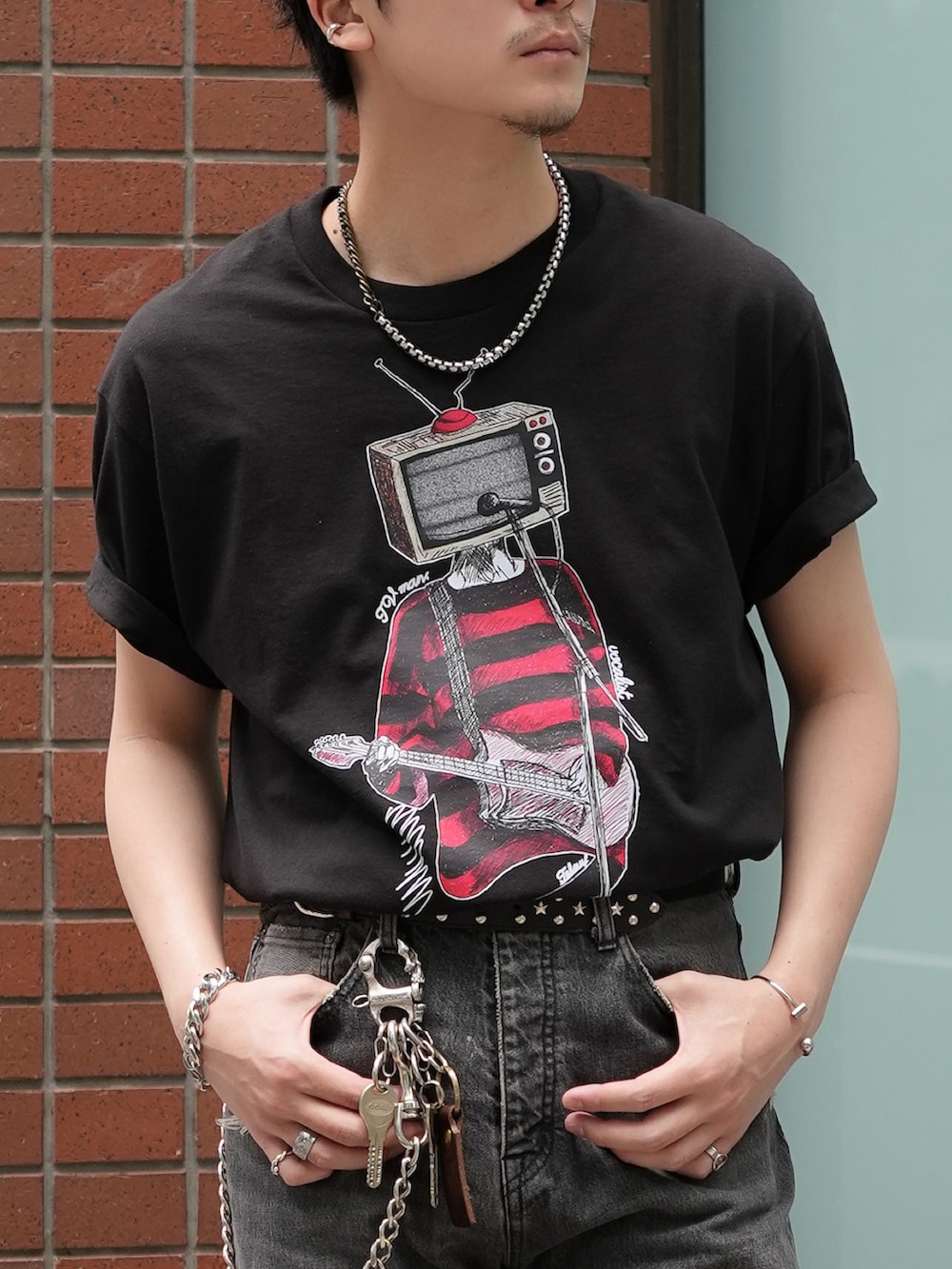 ブラック系のデニムパンツ、ブラック系のTシャツ/カットソー、ブラック系のブーツを着用したメンズの春コーディネートの4枚目の写真