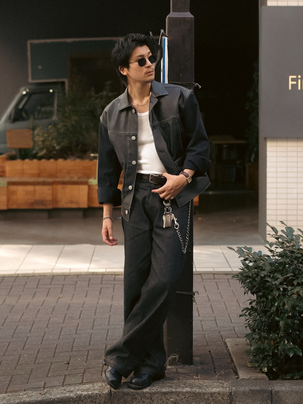 ブラック系のデニムパンツ、ブラック系のブルゾン、ホワイト系のタンクトップを着用したメンズの秋コーディネートの5枚目の写真