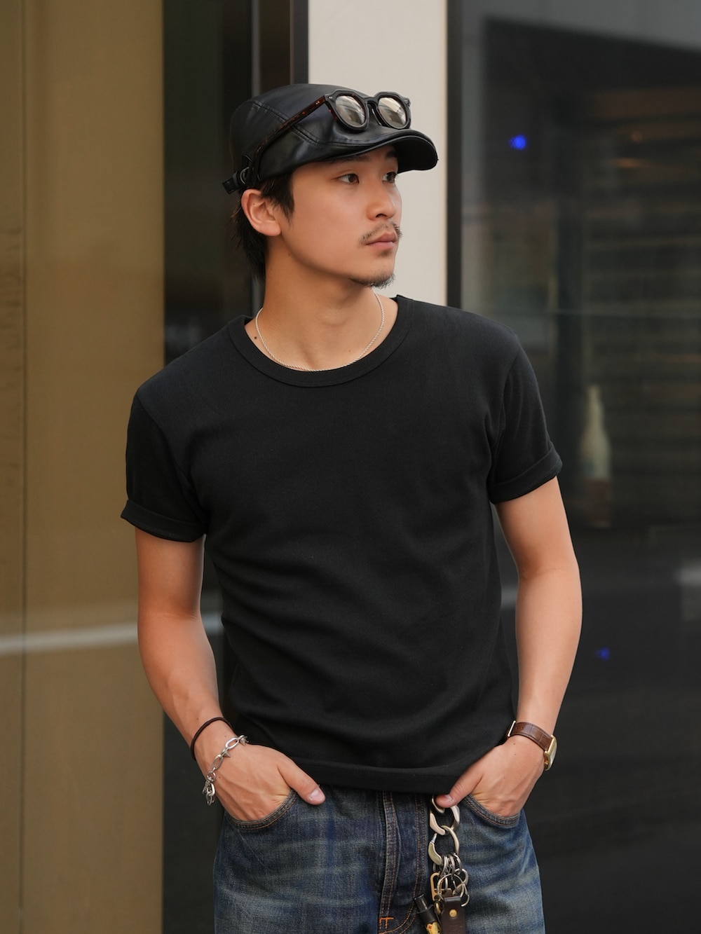 ブルー系のデニムパンツ、ブラック系のTシャツ/カットソー、ブラック系のブーツを着用したメンズの夏コーディネートの2枚目の写真