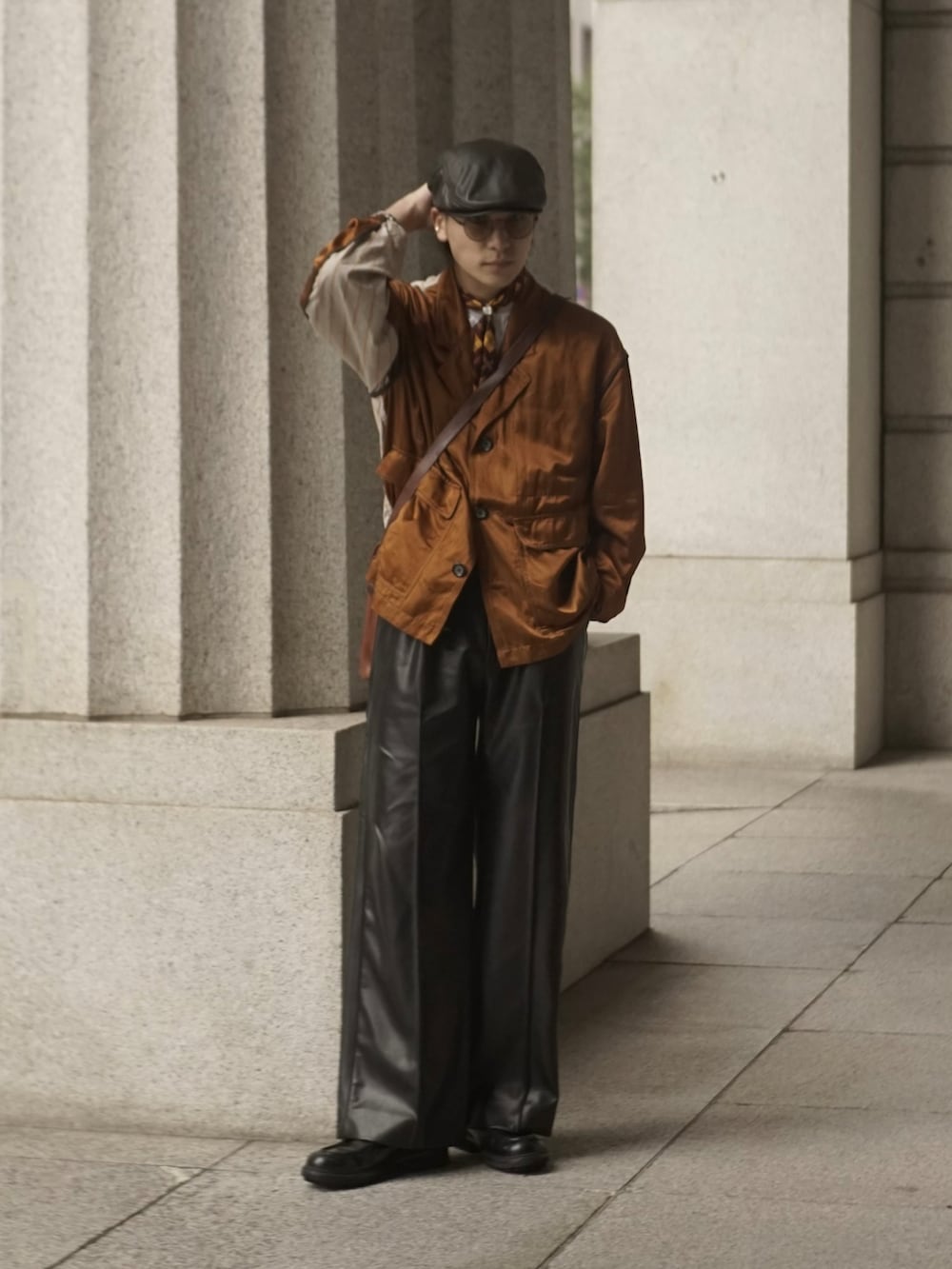 イエロー系のブルゾン、ブラウン系のショルダーバッグ、ブラック系のその他パンツを着用したメンズの秋コーディネートの4枚目の写真