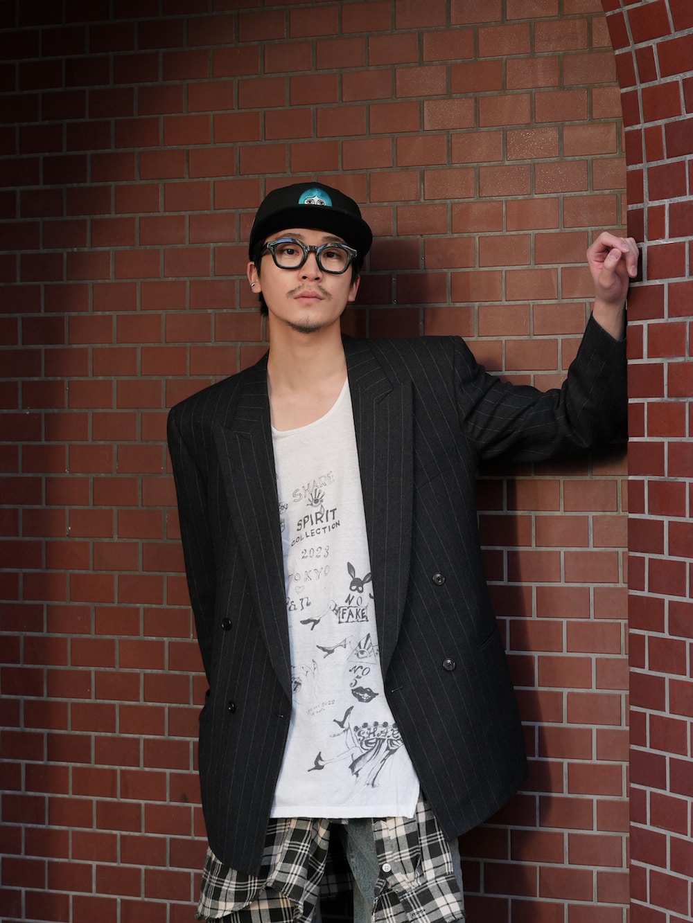 ブラック系のテーラードジャケット、ホワイト系のタンクトップ、ブルー系のデニムパンツを着用したメンズの冬コーディネートの2枚目の写真