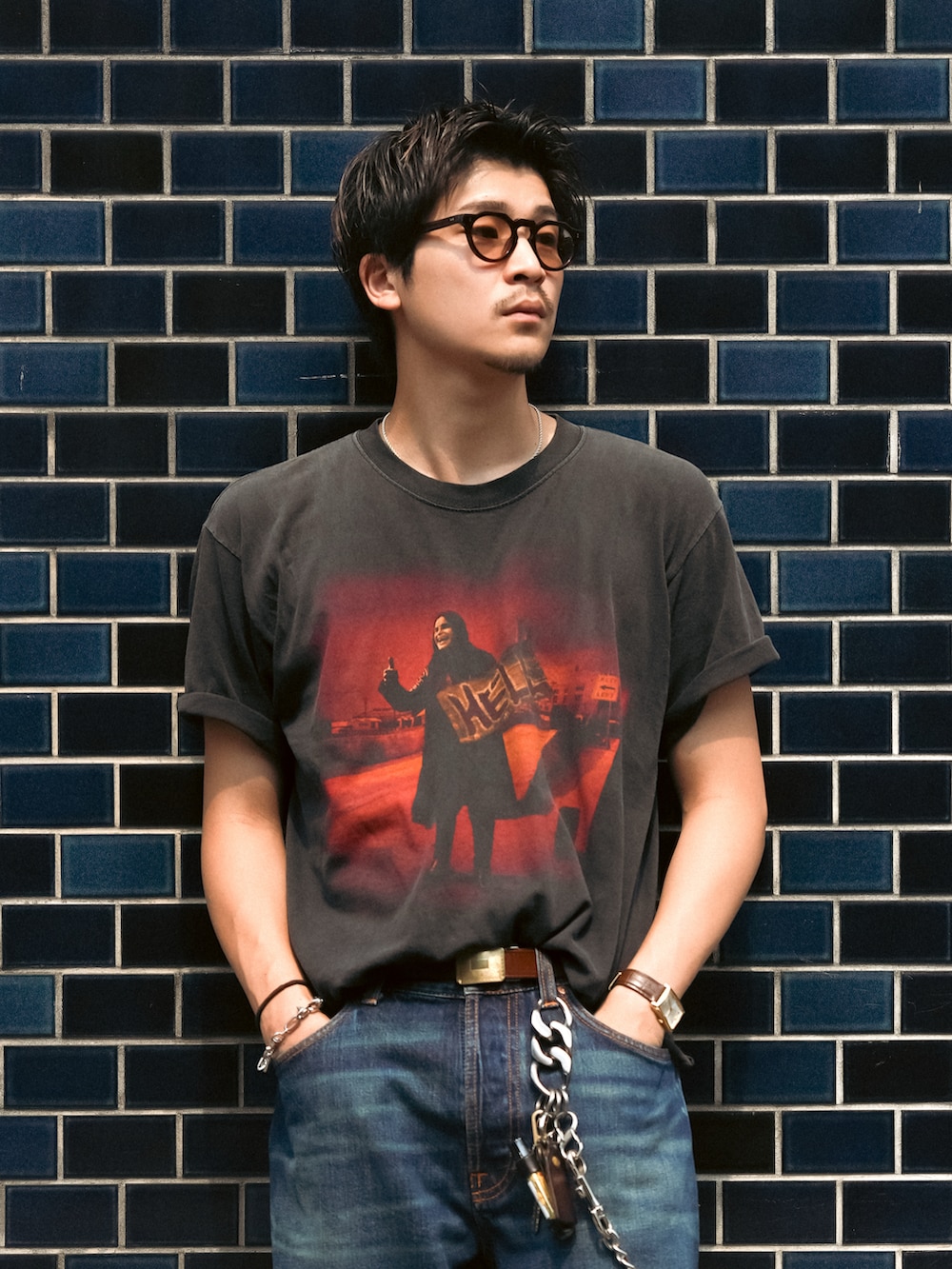ブルー系のデニムパンツ、ブラック系のブーツ、ブラック系のTシャツ/カットソーを着用したメンズの夏コーディネートの2枚目の写真