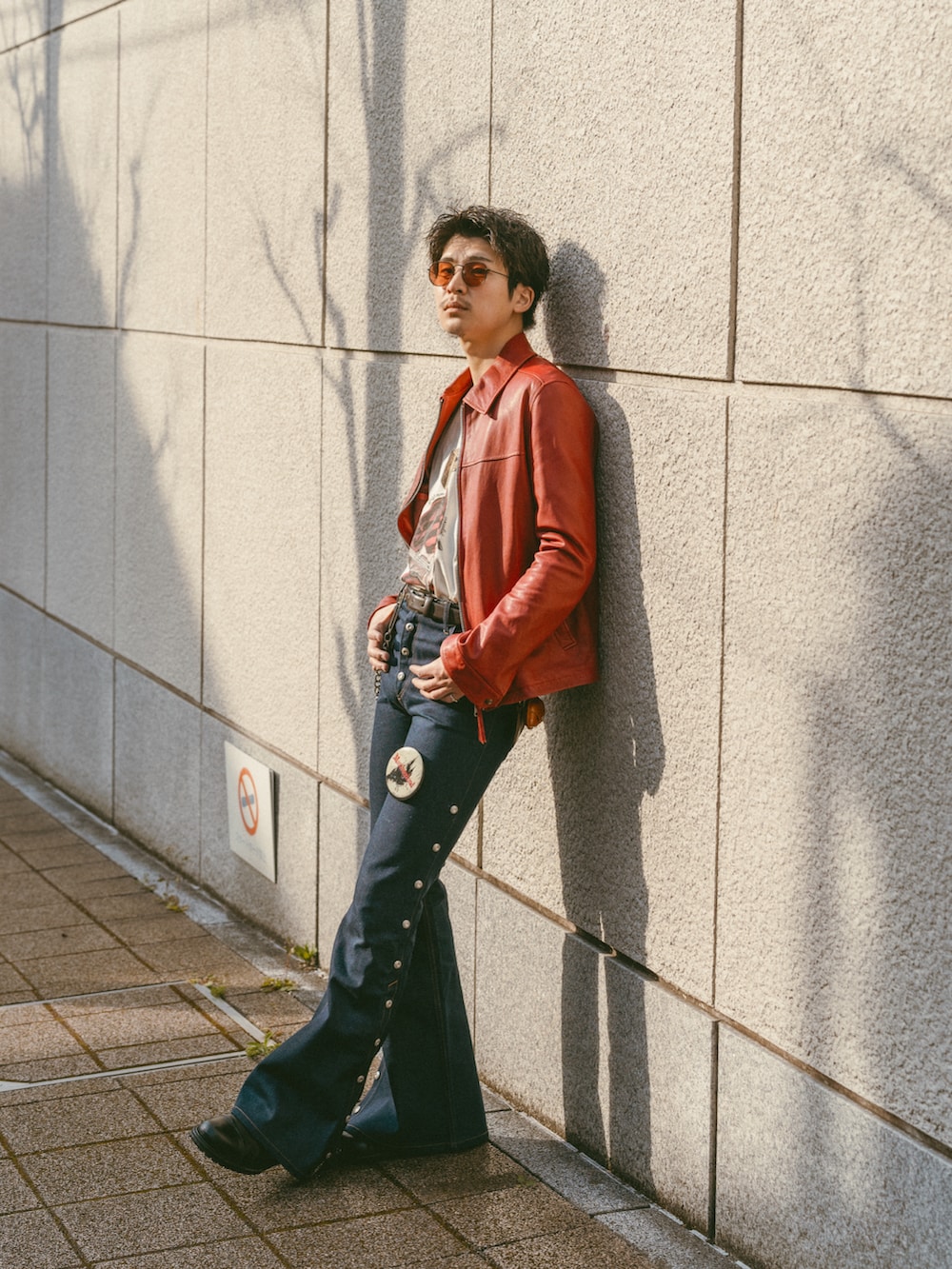 ブルー系のデニムパンツ、レッド系のその他アウター、ベージュ系のTシャツ/カットソーを着用したメンズの春コーディネートの4枚目の写真