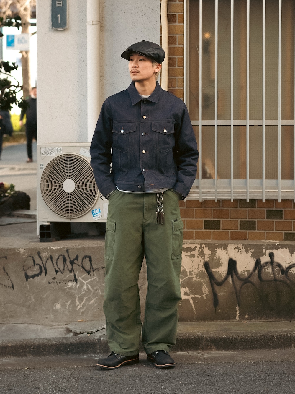 ブラック系のデニムジャケット、グリーン系のカーゴパンツ、ブラック系のブーツを着用したメンズの冬コーディネートの5枚目の写真