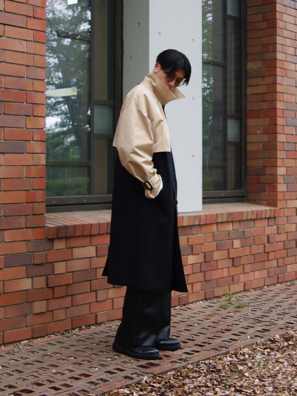 ブラック系のトレンチコート、ブルー系のベスト、ブラック系のドレスシューズを着用したメンズの春コーディネートの4枚目の写真