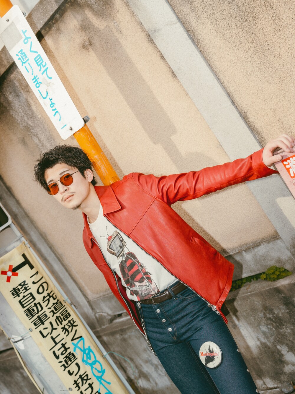 ブルー系のデニムパンツ、レッド系のその他アウター、ベージュ系のTシャツ/カットソーを着用したメンズの春コーディネートの3枚目の写真