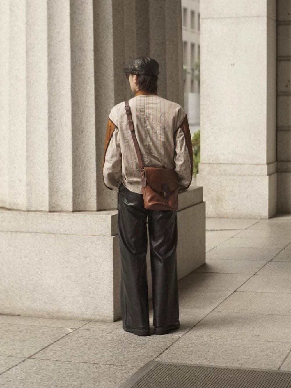 イエロー系のブルゾン、ブラウン系のショルダーバッグ、ブラック系のその他パンツを着用したメンズの秋コーディネートの3枚目の写真