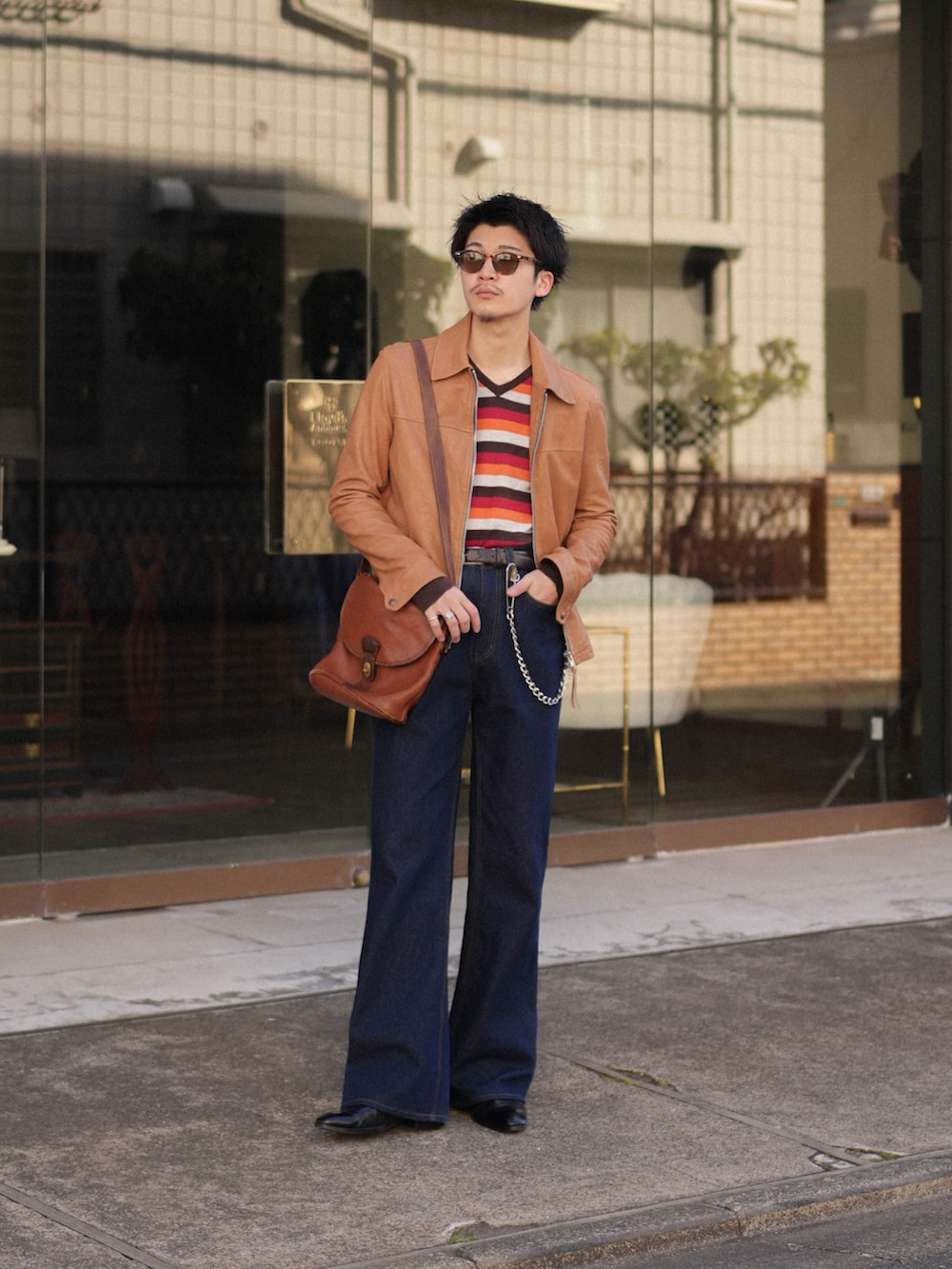 ブルー系のデニムパンツ、ベージュ系のその他アウター、レッド系のニット/セーターを着用したメンズの春コーディネートの4枚目の写真