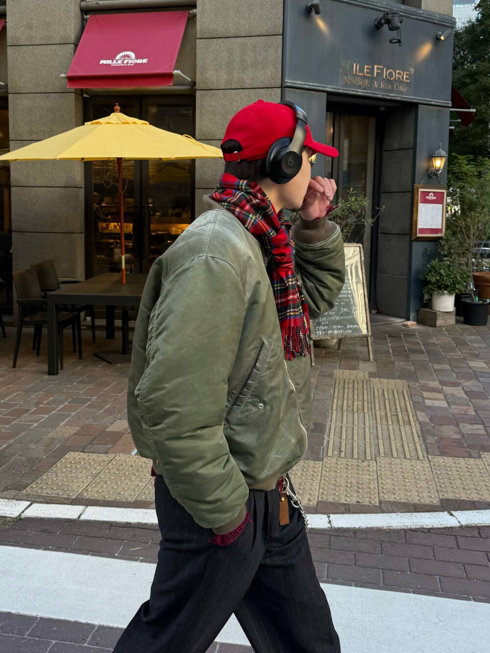 ブラック系のスラックス、ブラウン系のブーツ、グリーン系のMA-1を着用したメンズの冬コーディネートの5枚目の写真